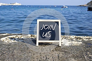 Join us symbol. Concept word Join us on black chalk background. Beautiful sea background. Business and Join us concept. Copy space