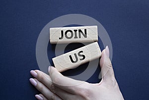 Join us symbol. Concept word Join us on wooden blocks. Beautiful deep blue background. Businessman hand. Business and Join us