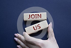 Join us symbol. Concept word Join us on wooden blocks. Beautiful deep blue background. Businessman hand. Business and Join us