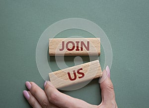 Join us symbol. Concept word Join us on wooden blocks. Beautiful grey green background. Businessman hand. Business and Join us