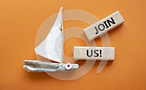 Join us symbol. Concept word Join us on wooden blocks. Beautiful orange background with boat. Business and Join us concept. Copy