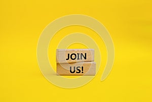 Join us symbol. Concept word Join us on wooden blocks. Beautiful yellow background. Business and Join us concept. Copy space