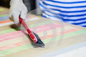 Joiner brush cleans the surface of the wooden table