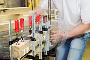 Joiner fixes glued wooden parts. Furniture workshop