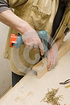 Joiner making furniture in his manufactory photo