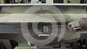 Joiner processing the workpiece of wooden plank by jointing machine