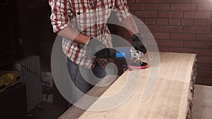 Joiner is sanding a board for furniture production