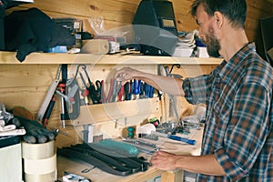 Joiner woodworker choosing construction carpentry tools in his workshop. DIY concept