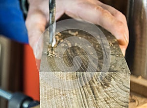 Joinery- Drill press on wood close up.