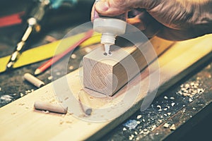 Joinery - joiner put the glue into a drilled hole for wooden dowel joint