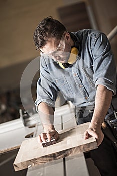 Joinery man polishing up wood photo