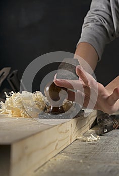 Joinery. Planing a natural wood furniture panel with a manual planer