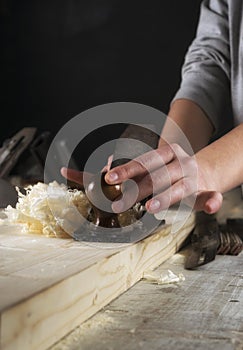 Joinery. Planing a natural wood furniture panel with a manual planer