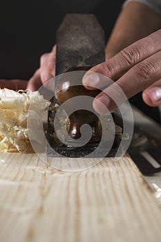 Joinery. Planing a natural wood furniture panel with a manual planer