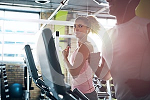 Joining this gym was a good idea. a man and a woman working out together in the gym.