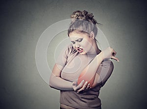 Joint inflammation with red spot on female's elbow. Arm pain injury concept. Woman with painful elbow photo