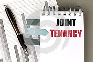 JOINT TENANCY text on notebook with chart on gray background photo