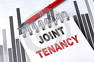 JOINT TENANCY text written on notebook with pen on chart photo
