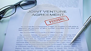 Joint venture agreement pending, hand stamping seal on business document