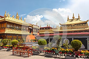 Jokhang temple gplden roof in Lhasa, Tibet from distance with a bench