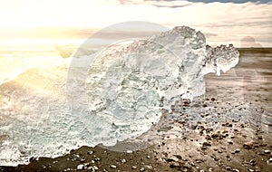 Jokulsarlon Diamond Beach with photographer moving close to iceberg on a sunny day, Iceland. Long exposure view