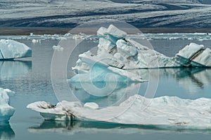 Jokulsarlon glacier lagoon bay with blue icebergs floating on st