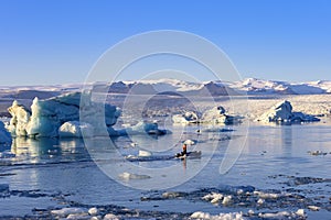 Jokulsarlon glacier lagoon in Iceland. Blue icebergs and tour boat on lake water. Northern nature landscape in Vatnajokull