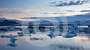 Jokulsarlon, glacier lagoon in Iceland at night with ice floating in water.