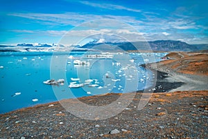 Jokulsarlon lake with icebergs on a sunny day, Iceland. Long exposure view with moving blocks of ice