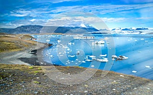 Jokulsarlon lake with icebergs on a sunny day, Iceland. Long exposure view with moving blocks of ice