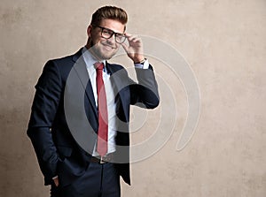 Jolly businessman fixing his glasses