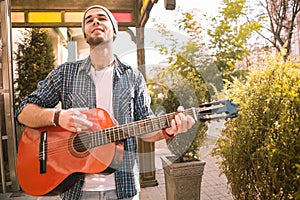 Jolly male guitarist perfecting skills on street