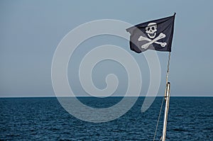 jolly roger. pirate flag.Against the background of blue sky