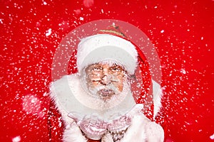 Jolly Santa Claus blowing in snow