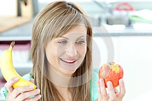 Jolly young woman holding an appke and a banana