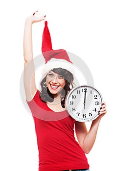 Jolly young woman in santa hat holding clock