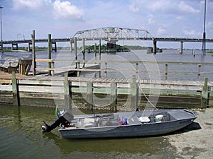 Jon boat with crab traps tied to dock and pushed up on boat land photo