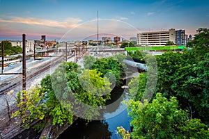 Jones Falls and a rail yard at sunset, seen from the Howard Street Bridge, in Baltimore, Maryland.