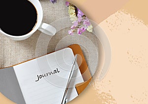 Journal Book with a Cup of Coffee on Background with Copyspace
