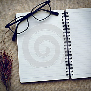 Journal book and eyeglasses on canvas background