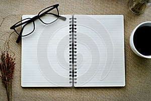 Journal book and eyeglasses with coffee in white cup