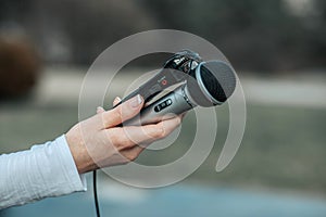 Journalist in hand holding microphone and dictaphone sound recorder at NEWS conference