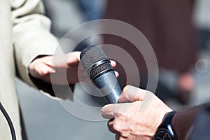 Journalist holding a microphone conducting an TV or radio interview