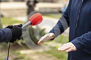 Journalist making media or vox populi interview with unrecognizable man on the street in the winter