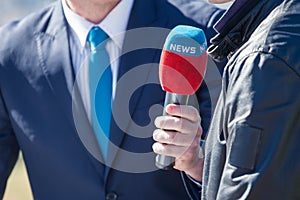 Journalist with microphone interviewing