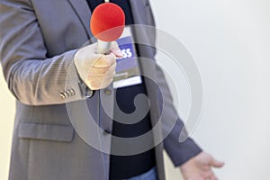 Journalist at news event, press conference or media interview holding microphone with copy space. Broadcast journalism concept.