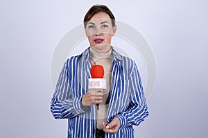 The journalist is speaking into a microphone while reporting the news