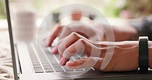 Journalist student typing a report on a laptop from home and zoom in of the hands of a male freshman studying and