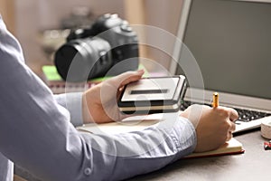 Journalist with voice recorder working at table in office, closeup