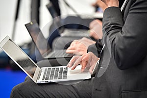 Journalists hands typing on laptops during a press conference